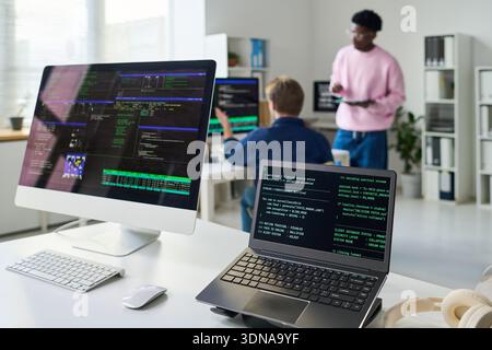 Young Man and Black Man Collaborating on Software Development Project Stock Photo