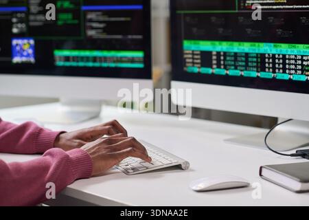 Young Black Woman Typing Code on Computer in Office Setting Stock Photo