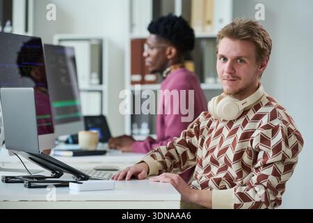 Portrait of Young Man Working at Computer in Office Stock Photo