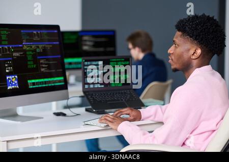 Young Black Man Working on Computer in Office Environment Stock Photo