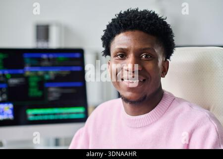 Portrait of Young Black Man Smiling While Working at Computer Desk Stock Photo
