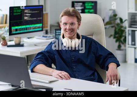 Portrait of Young Man Smiling While Working in Office Stock Photo