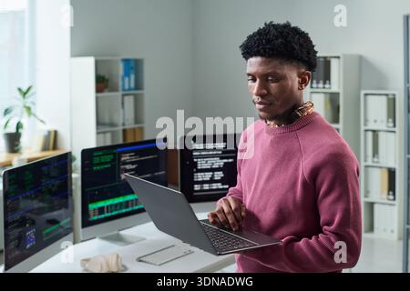 Young Black Man Using Laptop While Working in Office Environment Stock Photo