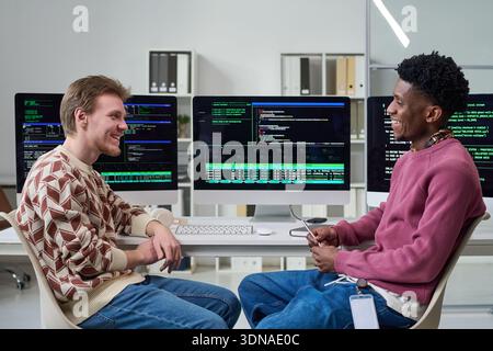 Young Men Collaborating in Office While Discussing Software Development Stock Photo