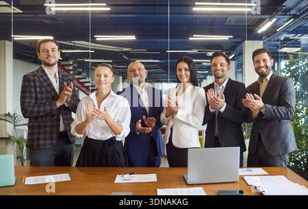 Diverse business team applauding in modern office meeting, celebrating success Stock Photo