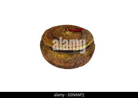 This is a hand-wrought copper and brass vessel from the Ladakh region featuring a low-profile, bulbous body with a nested, tassled lid. Maybe used for ceremonial purposes. Stock Photo