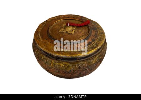 This is a hand-wrought copper and brass vessel from the Ladakh region featuring a low-profile, bulbous body with a nested, tassled lid. Maybe used for ceremonial purposes. Stock Photo