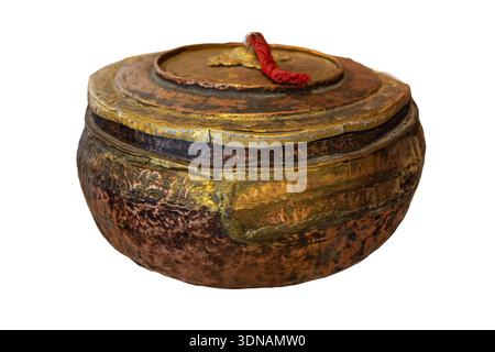 This is a hand-wrought copper and brass vessel from the Ladakh region featuring a low-profile, bulbous body with a nested, tassled lid. Maybe used for ceremonial purposes. Stock Photo