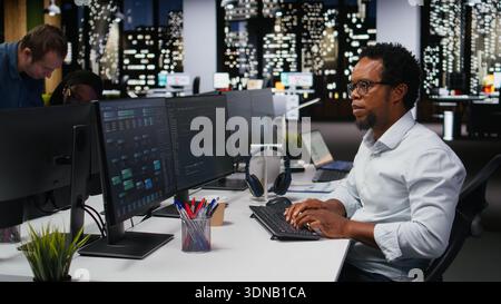 Engineer in Silicon Valley company office developing apps with AI. IT professional using machine learning to do coding, debugging applications to resolve issues Stock Photo