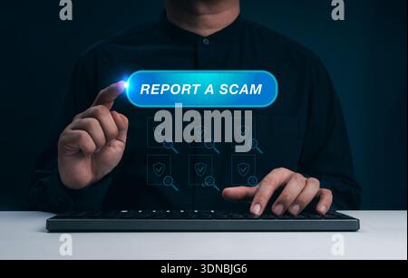 Man pressing Report a Scam button on virtual interface while using computer. Online fraud prevention, internet scam alert, cybersecurity awareness, an Stock Photo