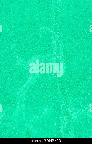 A green concrete wall with painted-over cracks. Stock Photo