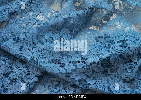 Close-up detail view of floral brocade fabric on a blue background. Stock Photo