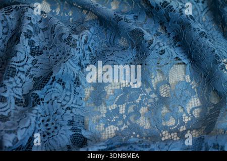 Close-up detail view of floral brocade fabric on a blue background. Stock Photo