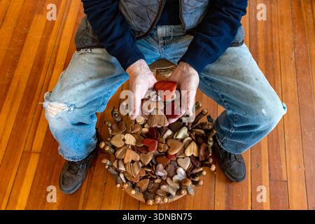Hands of artist Tommy Simpson holding his handmade wooden hearts - Asheville, North Carolina, USA Stock Photo