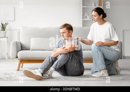 Young woman supporting man with suicidal thoughts at home Stock Photo