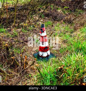 weathered orange reflector stripe road sign pin in the middle of a lawn Stock Photo