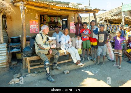 Madagascar, Atsimo-Andrefana region, Amnanihy on National Road 10 or RN10 which is only a track, a motorcyclist takes a break with the children Stock Photo