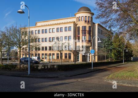 Exterior of the Action head office building in Hoofddorp, Netherlands. A modern beige office block with a circular corner tower and glass dome. Hoofdd Stock Photo