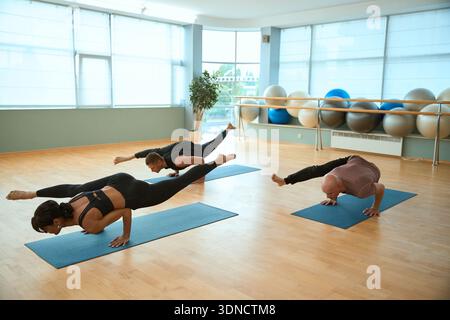 Sporty people doing a handstand on sport mat in yoga center Stock Photo