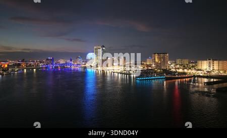Aerial view of the shimmering St. Johns River reflecting the illuminated skyline and bridges of Jacksonville at night, Jacksonville, Florida, United S Stock Photo