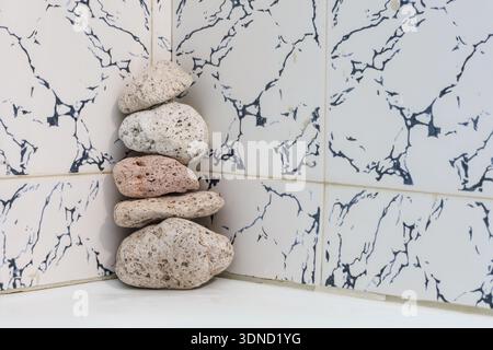 Raw exfoliating tools made from volcanic rock arranged in a quiet, clean bathroom space — ideal for sustainable lifestyle visuals. Stock Photo