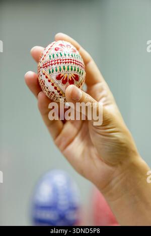 Romania, BuKovina region, Judet of Satu Mare (department of Satu Mare), Vama, the egg museum (Muzeul Ouloui) with the largest collection of painted eggs of Romania with 7 000 painted eggs from Romania and all over the world, a painted egg from Bukovino held in a hand Stock Photo