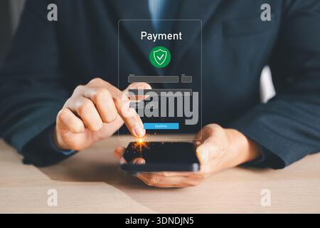 Businessman confirming secure mobile payment on smartphone with virtual checkout form and shield icon, fintech digital banking transaction for ecommer Stock Photo