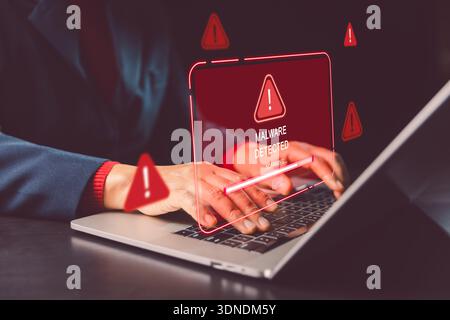 Hands typing on laptop with red malware detected warning and scanning bar, illustrating cybersecurity incident response, threat detection and data pro Stock Photo