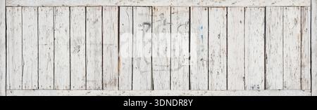 A white wooden wall with many cracks, holes, showing an old, rustic, weathered surface. Aged paint, splits, imperfections create strong depth, texture Stock Photo