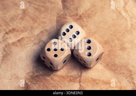 three wooden gambling dice with number six. Gambling dice old paper background Stock Photo