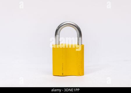 Yellow metal padlock on a light isolated background Stock Photo