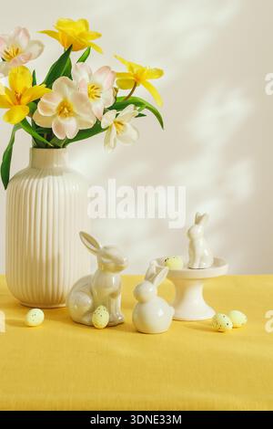 Bright Easter table with tulip flowers, bunnies and decorative eggs Stock Photo