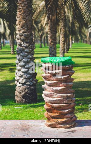 Middle East, United Arab Emirates, Emirate of Sharjah. Oasis AlNakheel. unusual waste garbage can made of palm trunks. Stock Photo