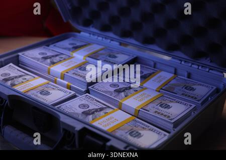 Stacks of new hundred dollar bills neatly arranged in a sturdy case, showcasing wealth and opportunity in a cozy setting Stock Photo