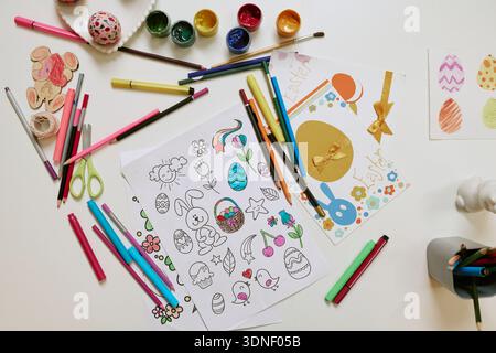 Child Coloring Easter Eggs and Bunny Drawings Using Markers and Crayons Stock Photo