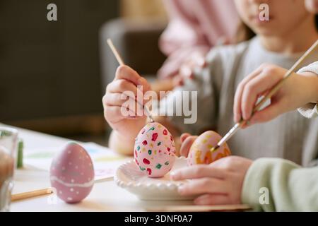 Child and Adult Decorating Easter Eggs Together Indoors Stock Photo