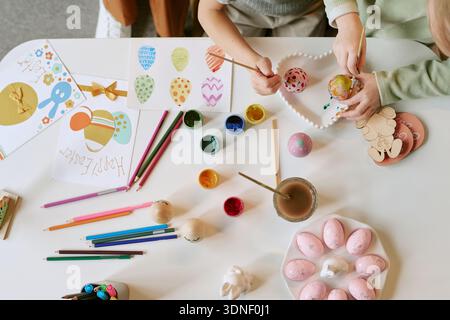 Children Painting Easter Eggs and Drawing Festive Decorations Together Stock Photo