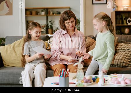 Middle Aged Woman Teaching Two Girls Arts and Crafts Stock Photo