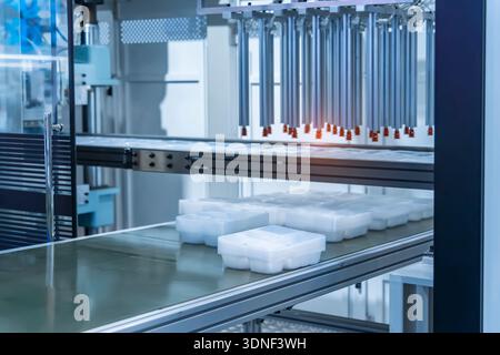 Stack of polypropylene food containers on conveyor belt of automatic plastic injection molding machine,automated technology concept Stock Photo
