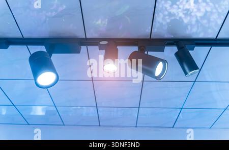 Ceiling with bright lights in a modern warehouse, shopping center building, office or other commercial real estate object. Directional LED lights on r Stock Photo