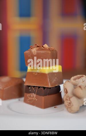Different types of chocolate stacked on a white plate Stock Photo