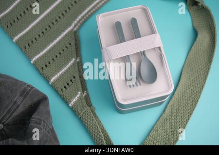 Lunch box and utensils on a table with a green cloth Stock Photo