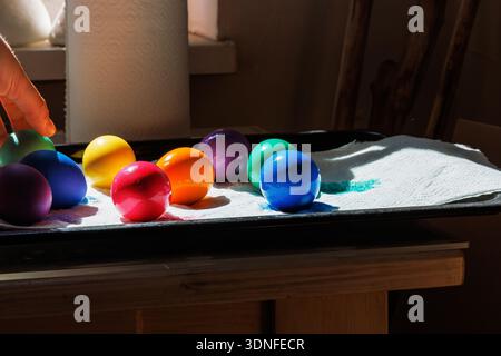 Side view of colorful dyed easter eggs in bright colors drying on a tray lined with paper towel Stock Photo