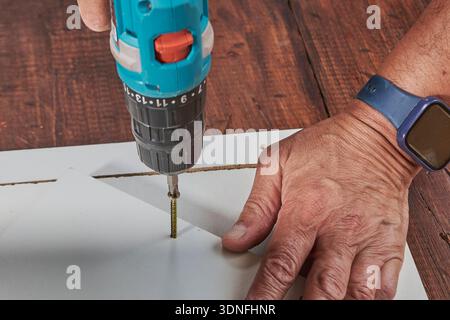 Handyman using power tool for home repair and carpentry work Stock Photo