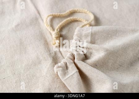 Creased light white grey color natural fabric from cannabis plant as background with copy space.  Bags from hemp material for storage of bread Stock Photo