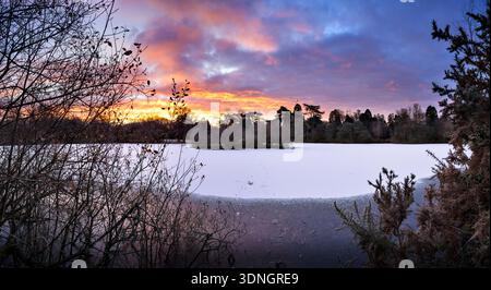 Sunrise over the frozen Cemetery Lake on Southampton Common in winter Stock Photo