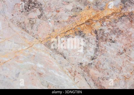 A close-up view reveals a stunning marble surface featuring intricate patterns and striking golden veins. This natural stone showcases an elegant mix Stock Photo