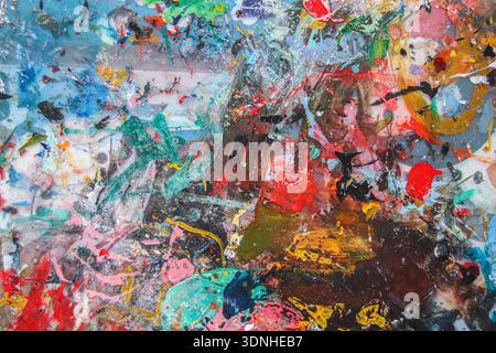 Abstract vibrant paint splatters on a messy artist desk. Creative texture for contemporary art, fashion, and education marketing content. Stock Photo