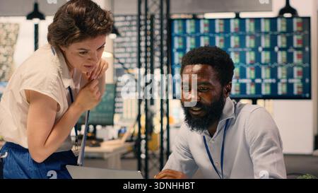Multinational work team analyzing business intelligence reports and metrics in a professional office workspace. Team collaboration focused on objectives and productivity, visual data. Stock Photo
