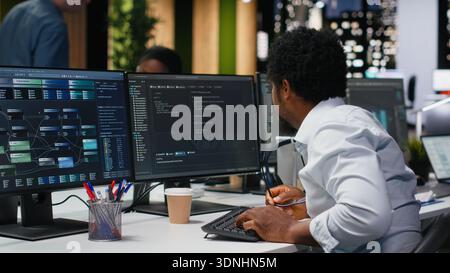 Engineer in Silicon Valley company office developing apps with AI. IT professional using machine learning to do coding, debugging applications to resolve issues Stock Photo